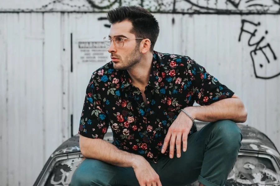 Homem balançando uma camisa floral multicolorida