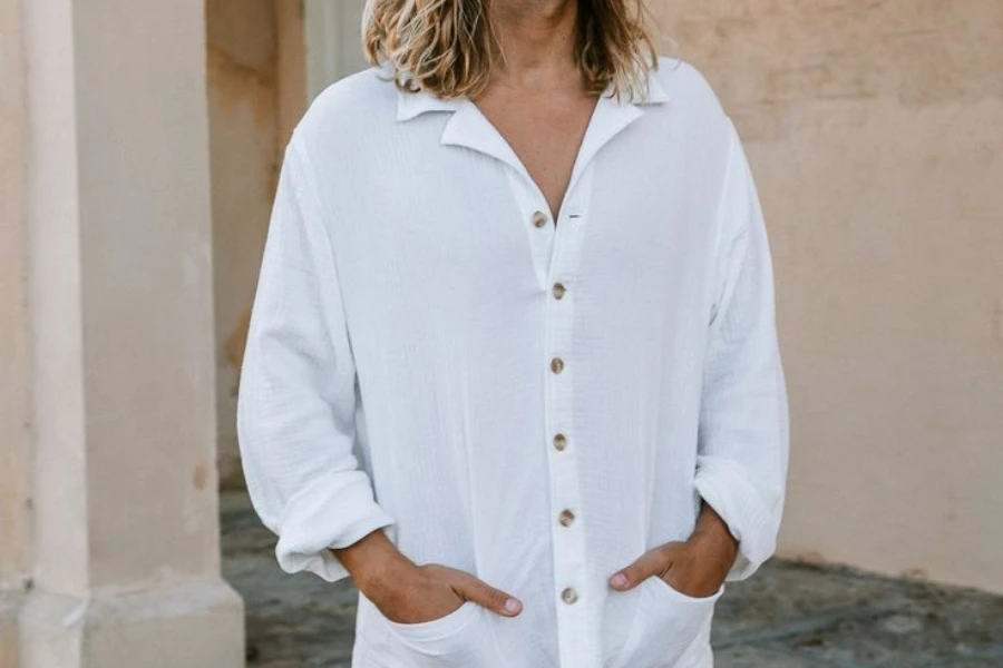 Man with hands in the pockets of white Henley shirt