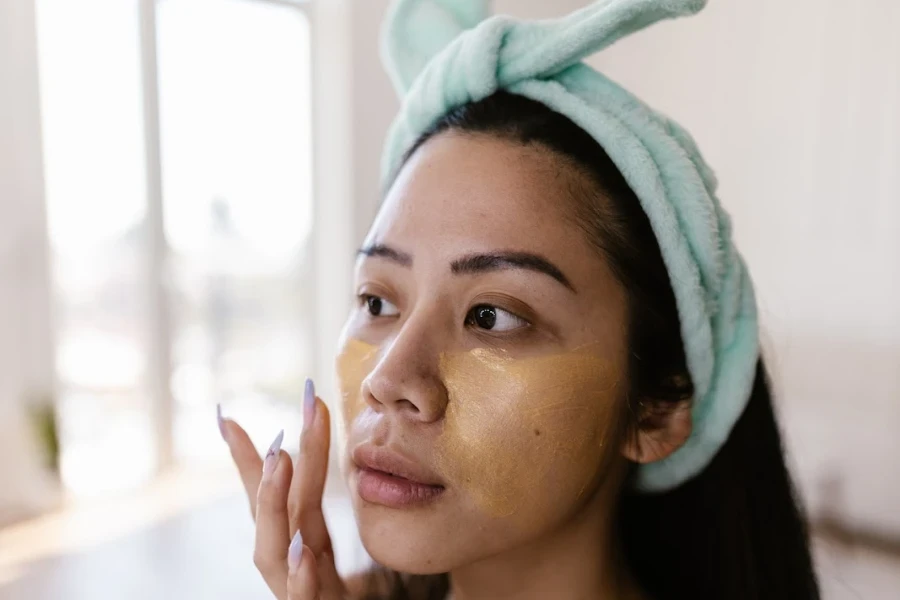 Person wearing a headband while putting on makeup