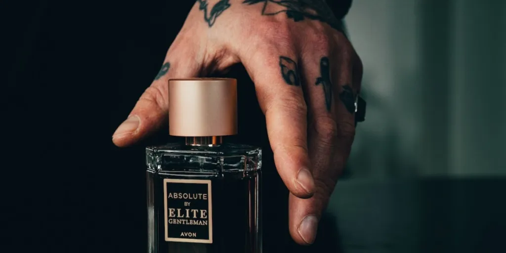 Person with a tattooed hand going to pick up a cologne bottle