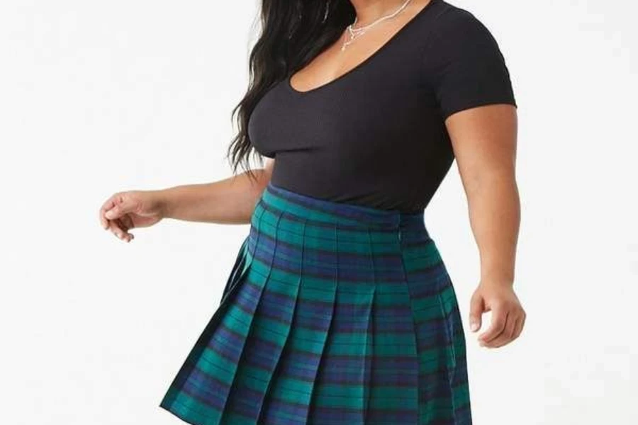 Mulher plus size usando saia plissada e camiseta básica