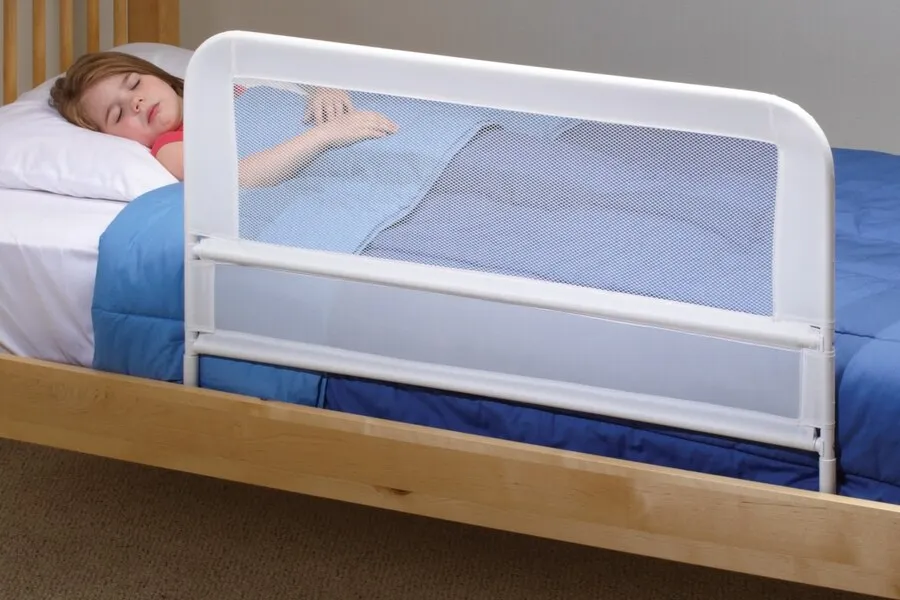 Sleeping child protected with a mesh bed rail