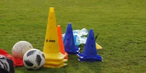 Balones de fútbol y conos en un campo de fútbol.