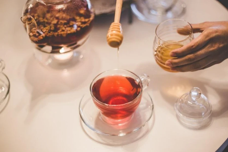 Thé dans une tasse à thé en verre transparent avec soucoupe