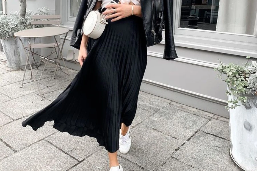 Walking lady wearing a black pleated midi skirt