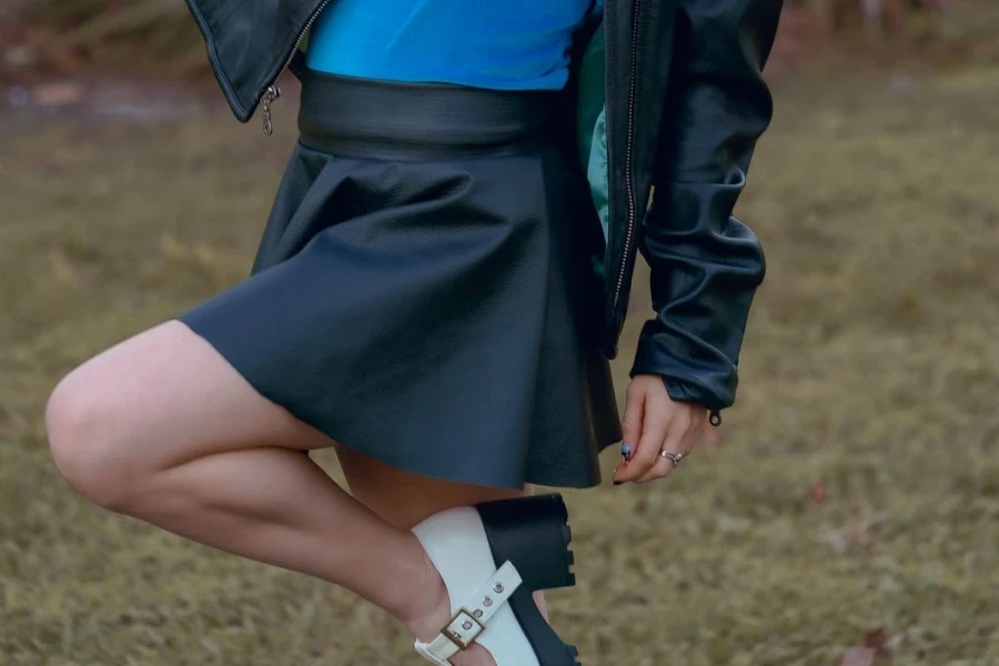 Woman playfully posing in a mini leather skirt