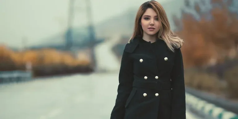 Woman posing in a short black coat