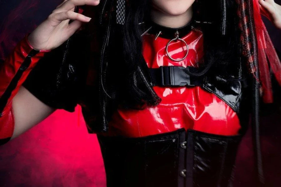 Wanita berpose dengan pakaian festival cybergoth merah yang reflektif