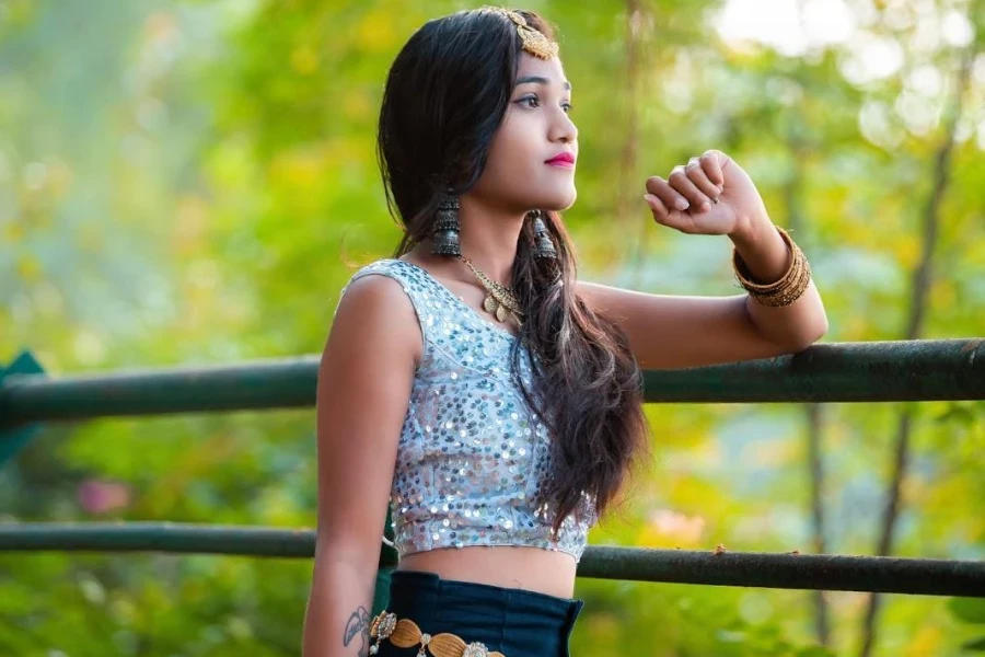 Woman resting on rails in a sequin crop top