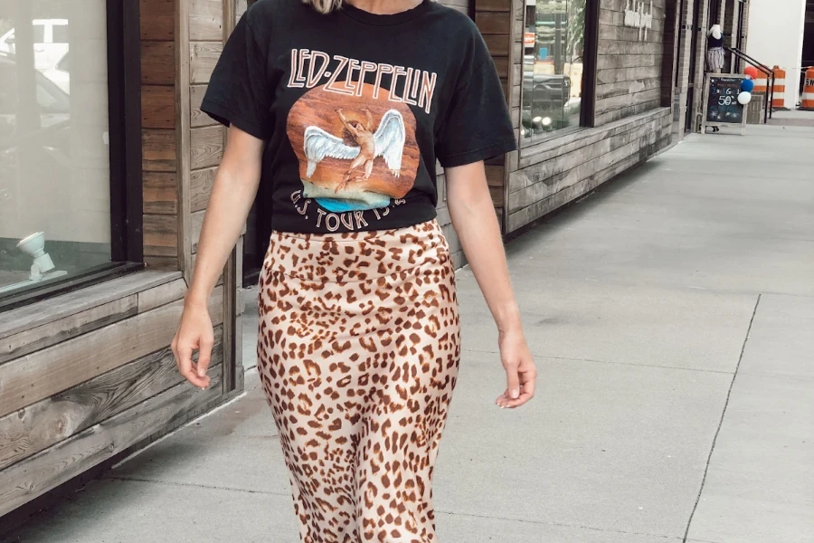 Mulher usando camiseta de banda e saia maxi com estampa animal