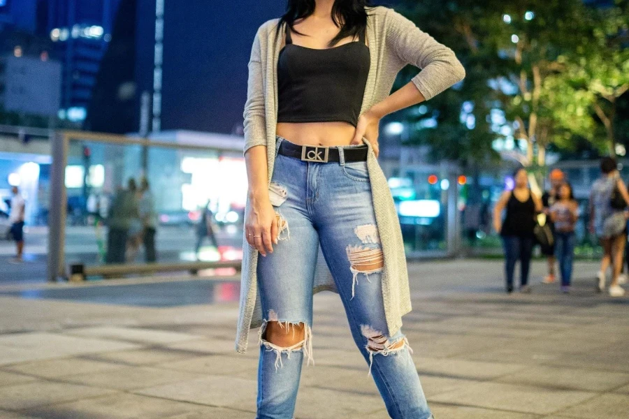 Wanita mengayunkan denim robek biru