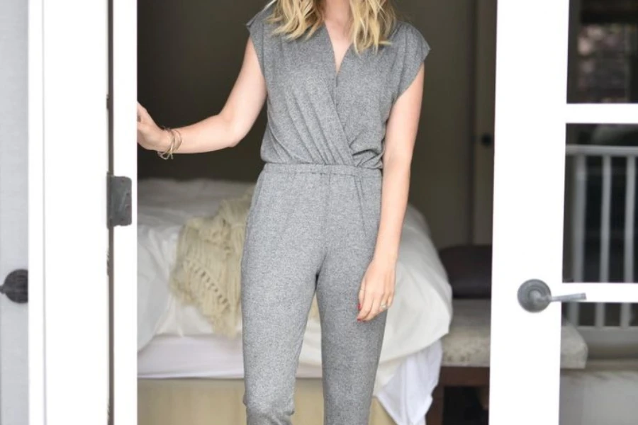 Woman rocking a cashmere jumpsuit in a bedroom