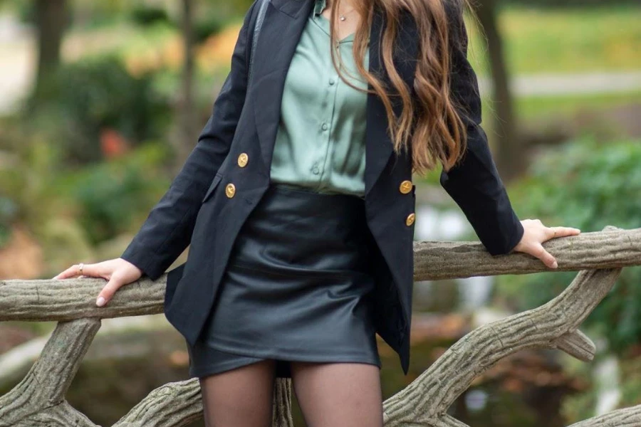 Woman sitting on a branch in a leather mini skirt
