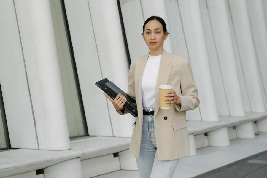 Woman wearing a light brown tailored jacket with denim trousers