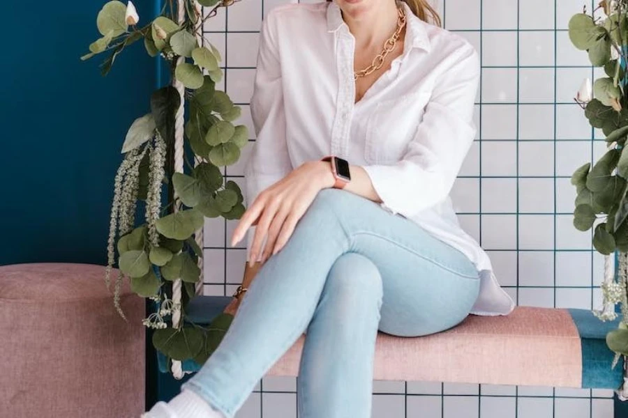 Woman wearing a white button-up shirt over denim jeans