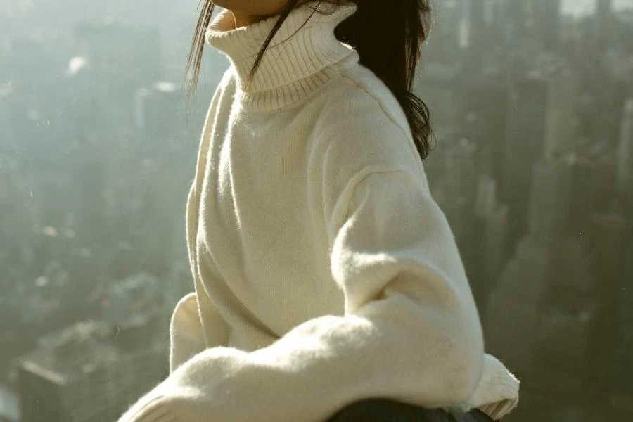 Woman wearing a white, turtleneck, chunky oversized knit sweater