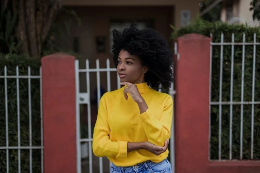 Femme portant un haut volumineux jaune avec un jean