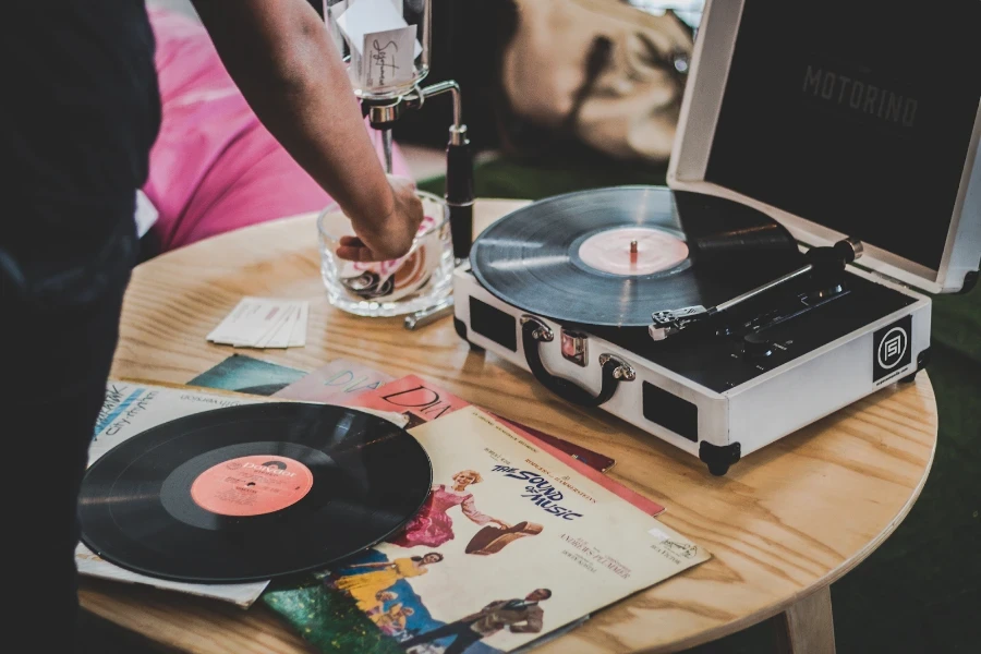 Personnes autour d’une platine vinyle à entraînement par courroie inactive