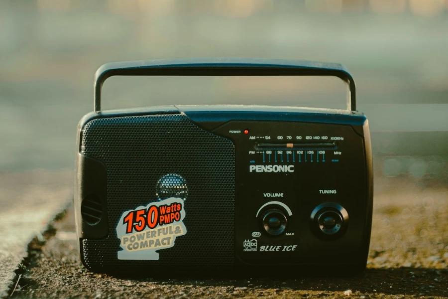 Una radio portátil negra con pegatinas en una carretera.