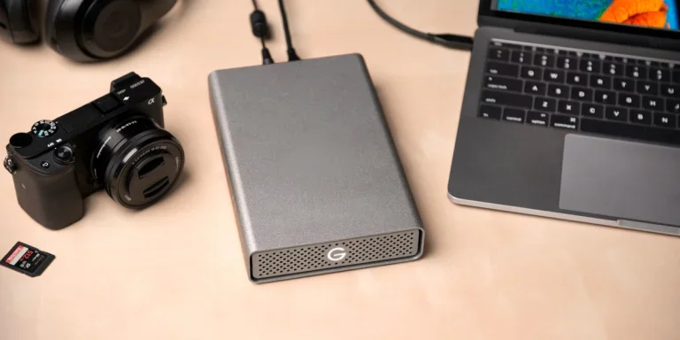 a camera, hard drive, and computer on a desk