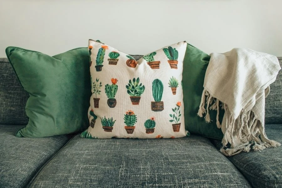 A couch with a woolen blanket with tassels