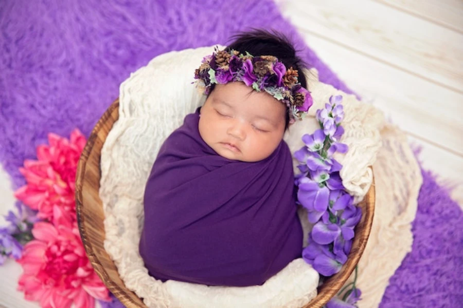 A cute little baby wrapped in a purple swaddle