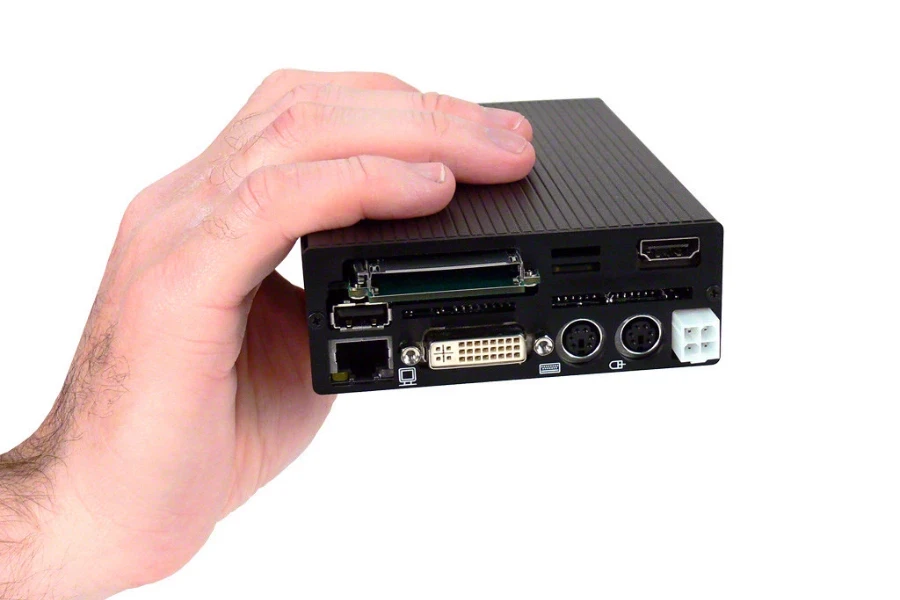 une main tenant un mini PC