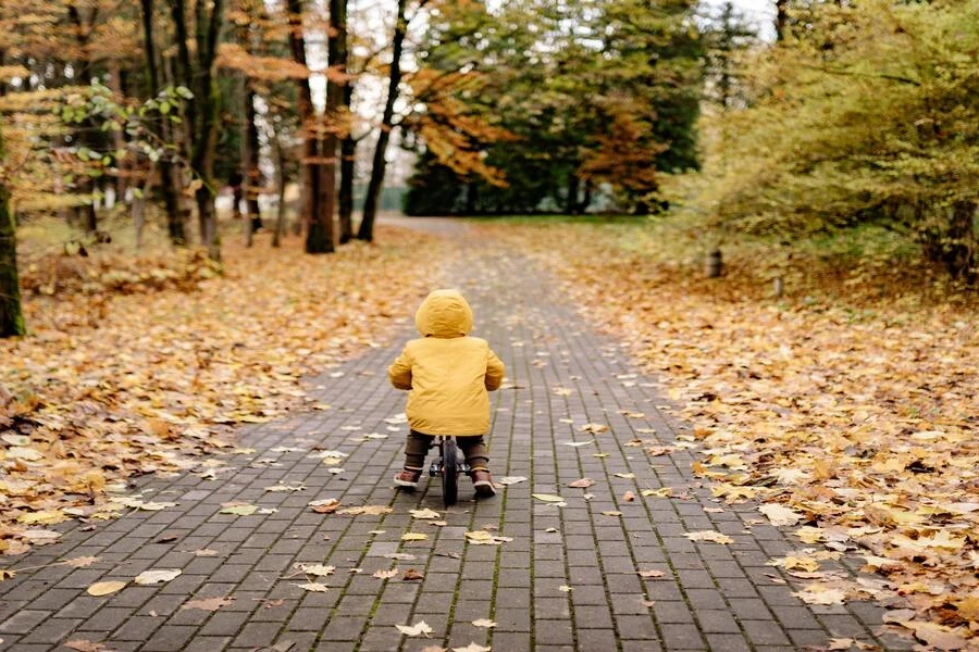 Uma criança andando em um veículo elétrico em um parque