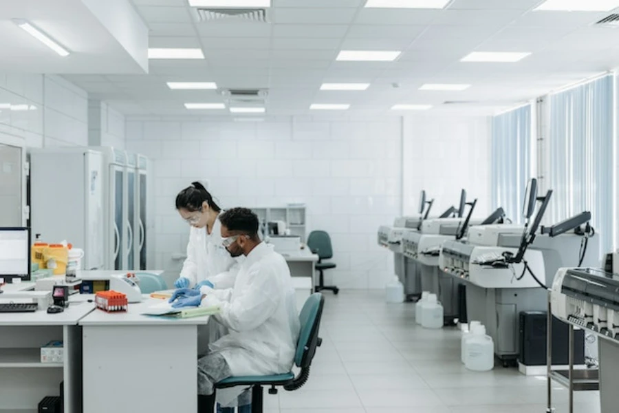 A man and woman in a medical laboratory wearing white scrubs
