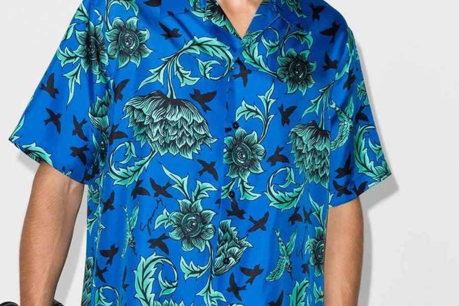 Un uomo che indossa una maglietta da bowling blu ispirata al tiki