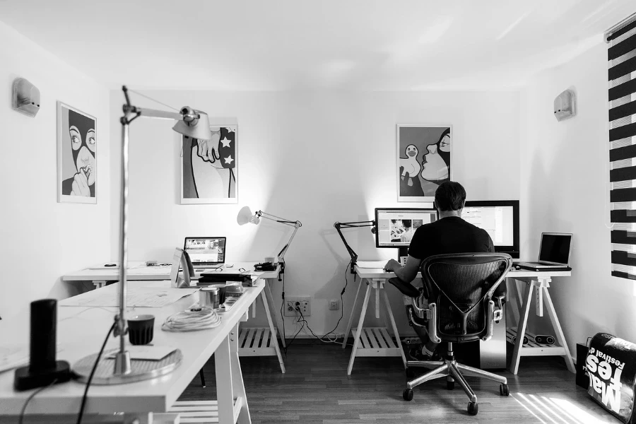 Ein Mann sitzt auf einem Drehsessel in seinem Heimbüro