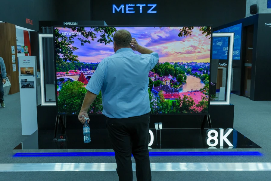 a man standing in front of an 8k tv