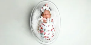 Bayi baru lahir terbungkus bedong bermotif bunga