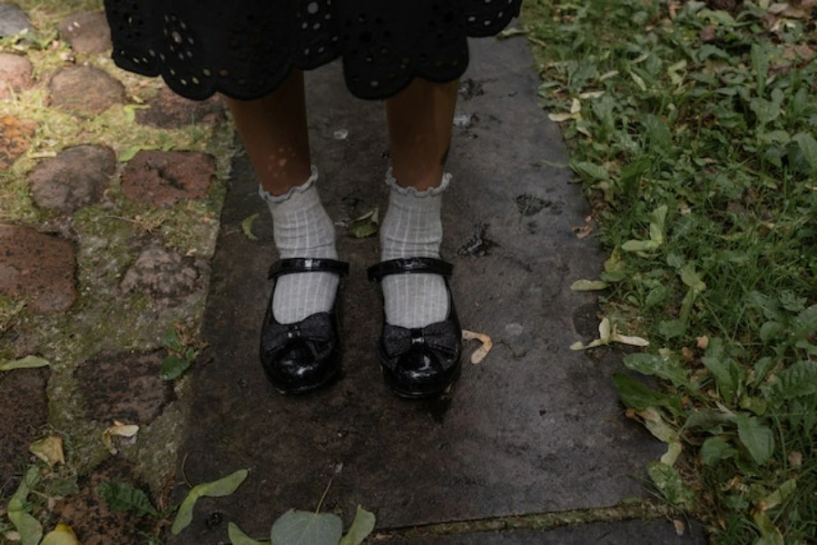 Um estudante usando sapatos escolares pretos e meias brancas