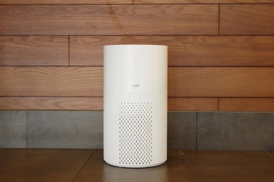 A white air purifier kept near a wooden wall