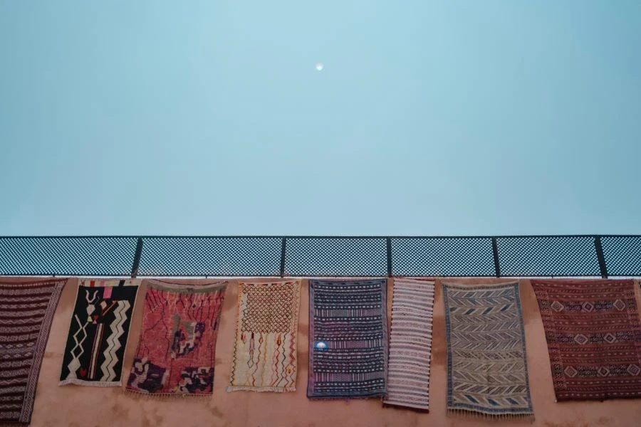 Assorted colored rugs on a wall