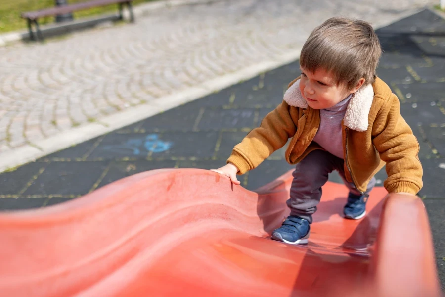 boy climbing wave slides