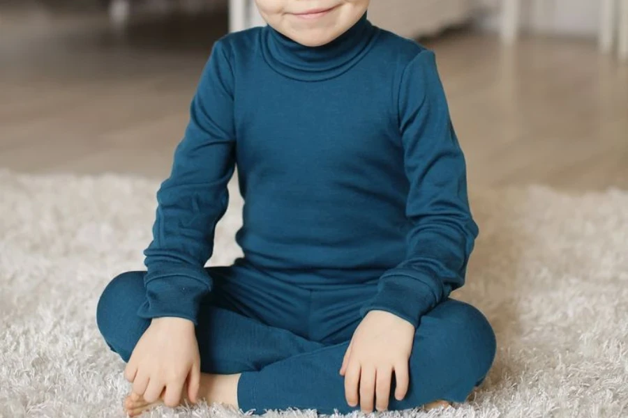 Junge sitzt im blauen Baselayer