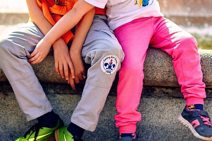 Boys sitting on a fence in fleece pants