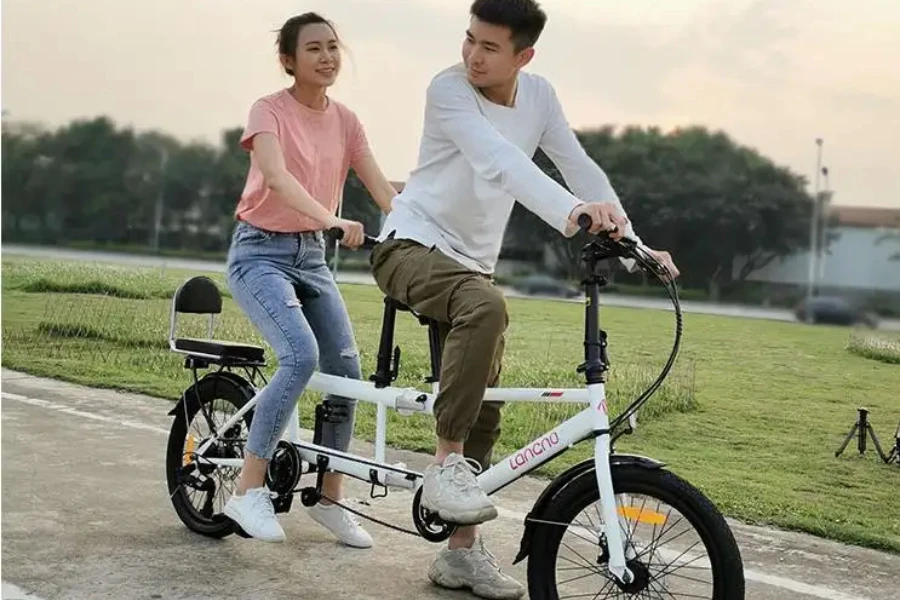 Couple riding folding tandem bike with thick white frame