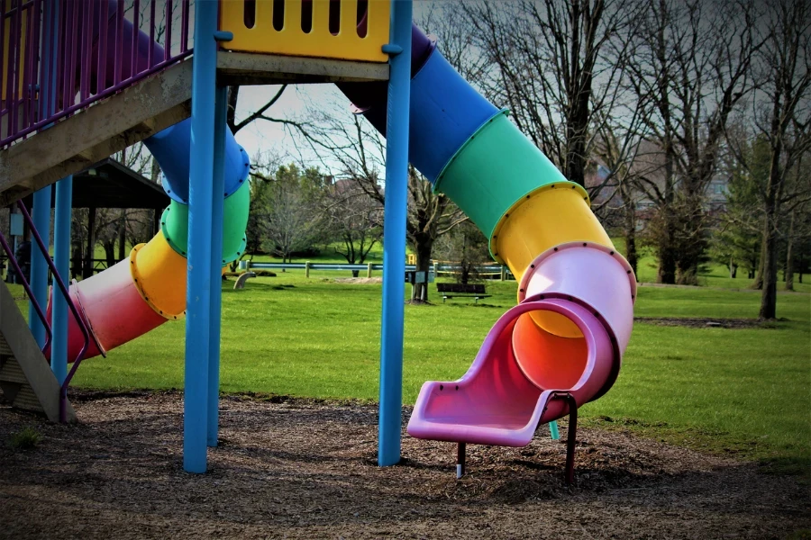 Toboganes infantiles multicolores con piscina seca con gran cantidad de  bolas. patio de juegos vacío