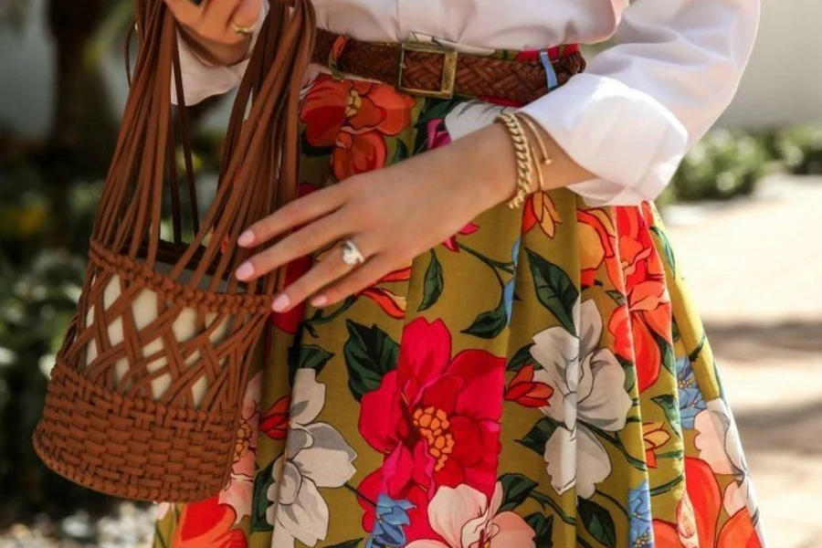 signora che tiene una borsa mentre indossa una gonna a ruota intera floreale