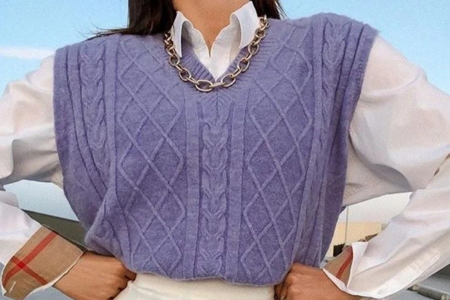 Señora posando con un chaleco y una camisa blanca