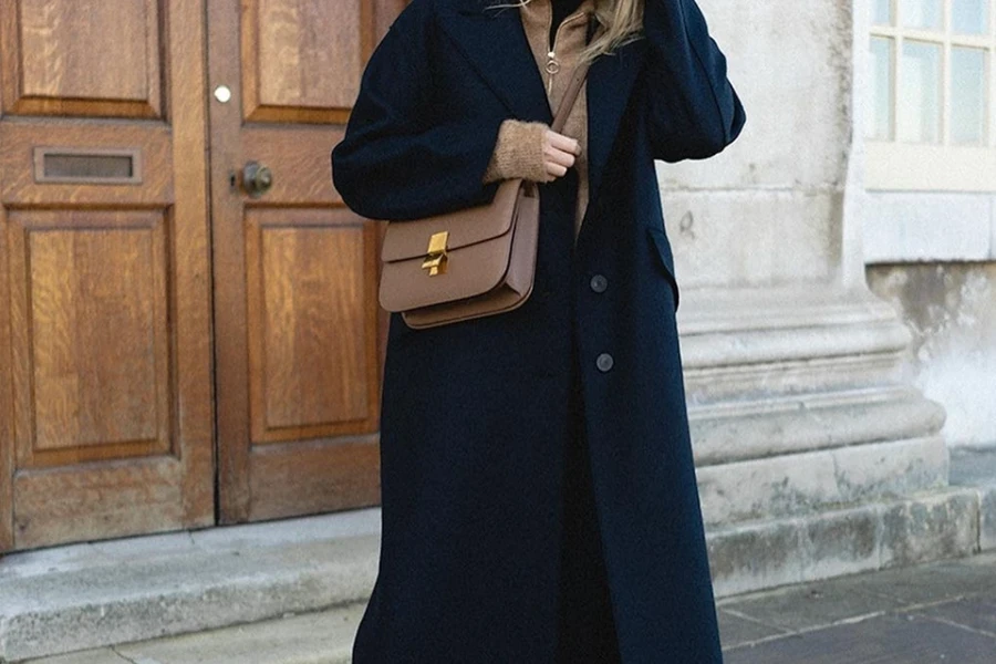 Signora pronta a muoversi con indosso un cappotto di lana nera