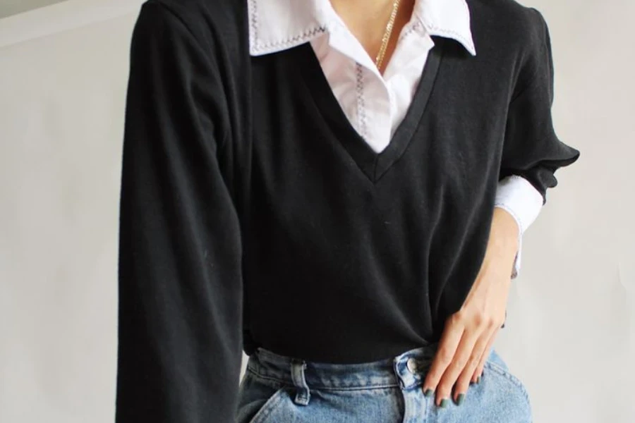 Lady wearing a black sweater on blue jeans