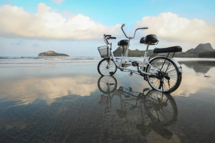 Light blue tandem bike with basket sitting on beach