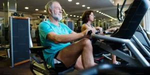 Man and woman sitting on recumbent bike at the gym