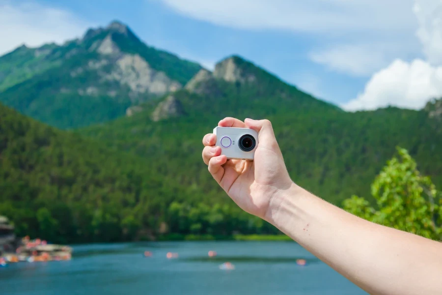 Man holding an action cam in the mountains