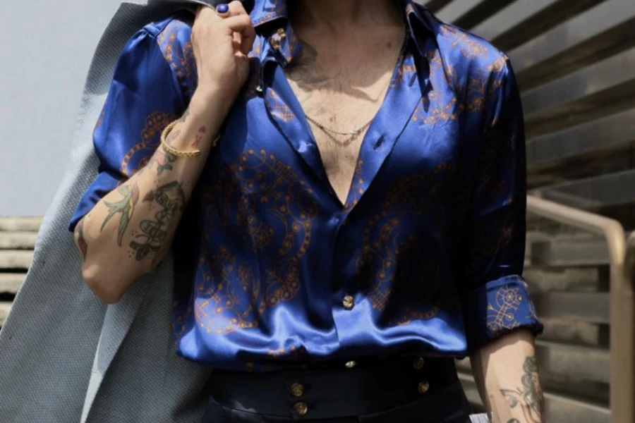 Uomo in posa con stile in una camicia di seta blu