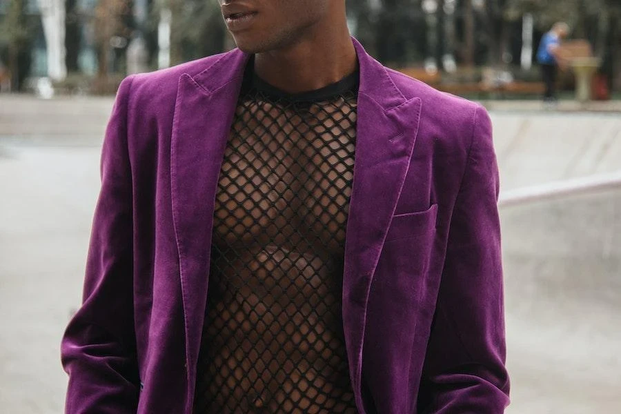 Homem usando uma jaqueta de veludo roxo e camisa de rede